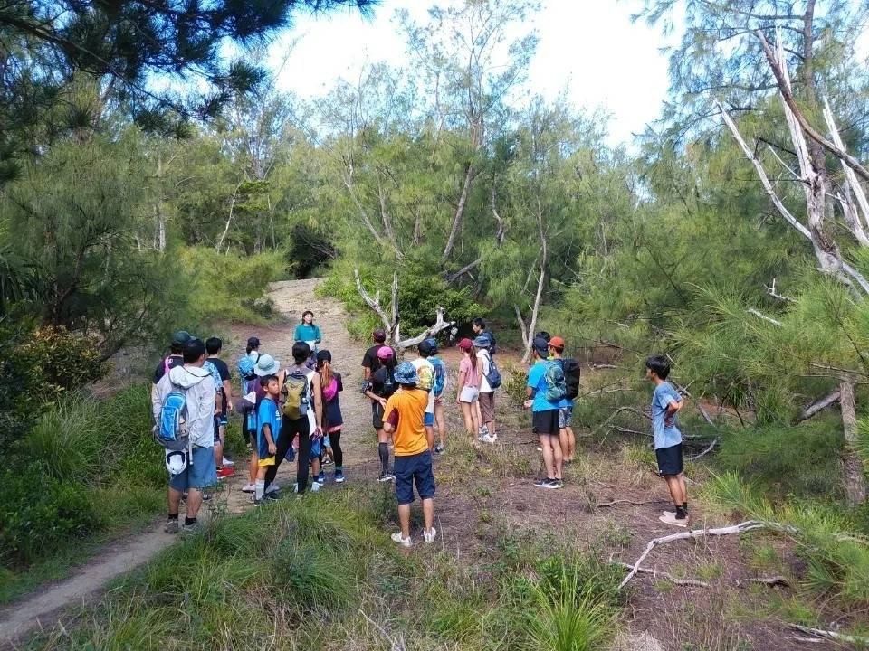 山道で講師の説明を聞くトレイルランニング講習会の参加者たち